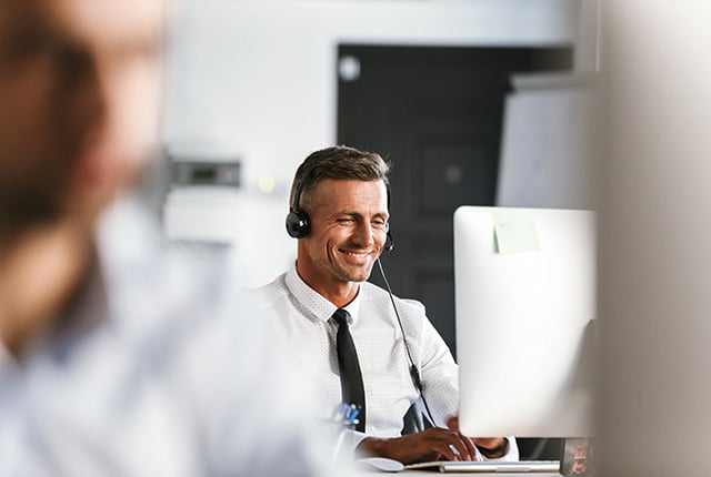 happy employee smiling while using his computer