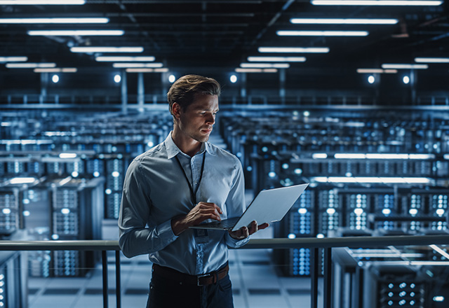 IT Specialist Using Laptop in Data Center