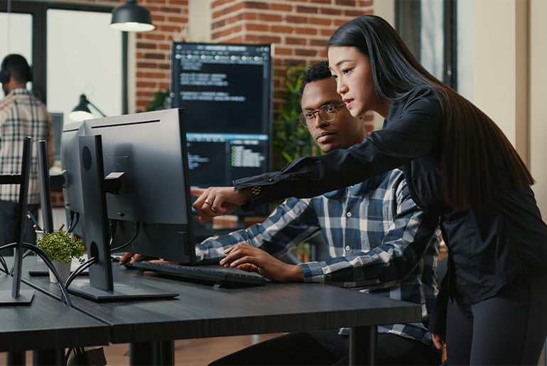 hombre y mujer señalan a un ordenador