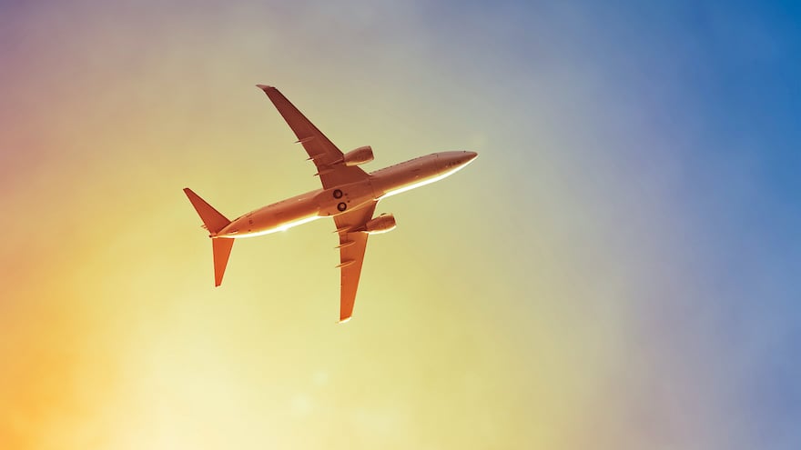 An image of a plane in the sunset sky