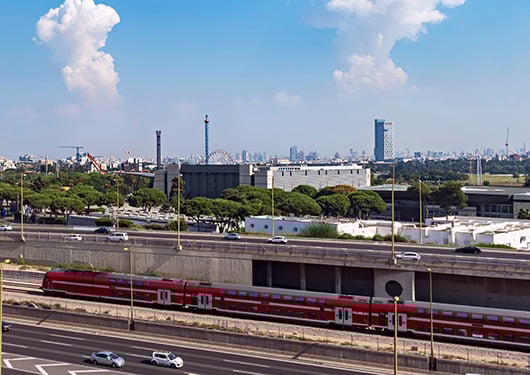 Train traveling through Tel Aviv cityscape